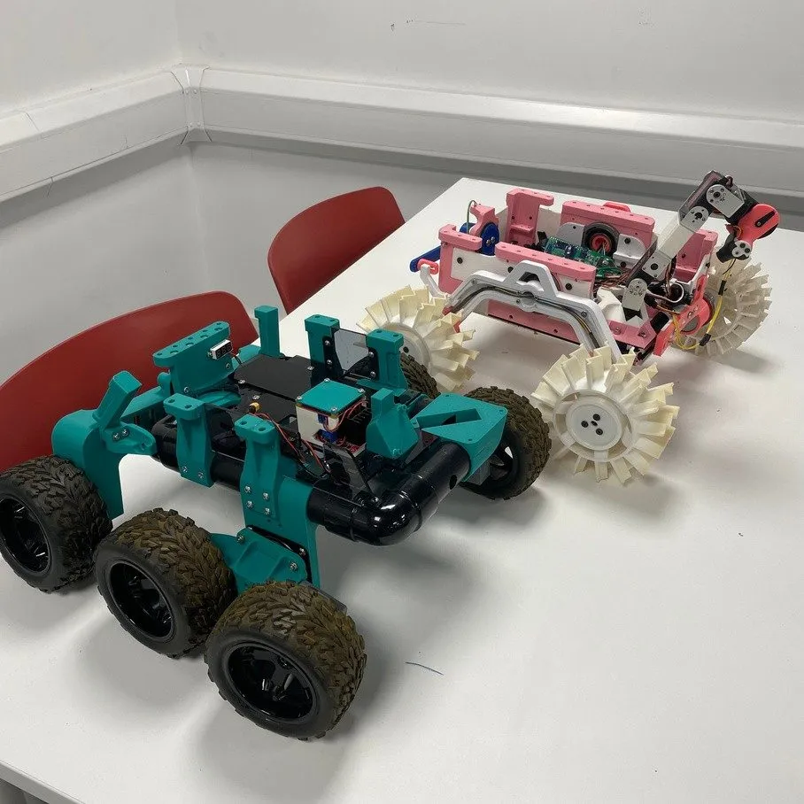 A teal 3D-printed rover with chunky off-road wheels