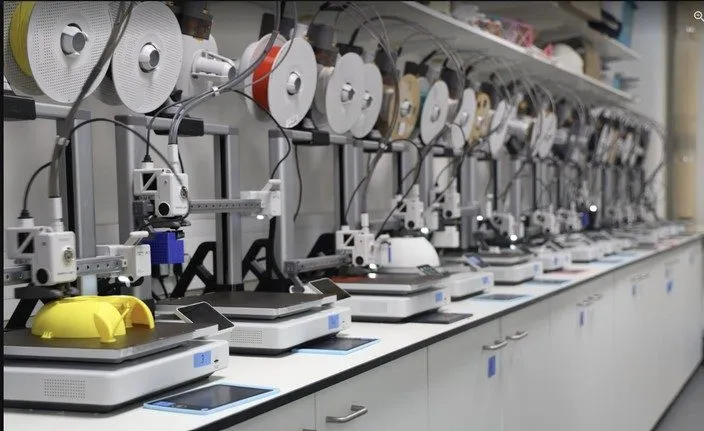 A long row of Bambu 3D printers mid-print