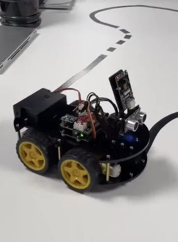 A small four-wheeled line-follower robot on a taped track
